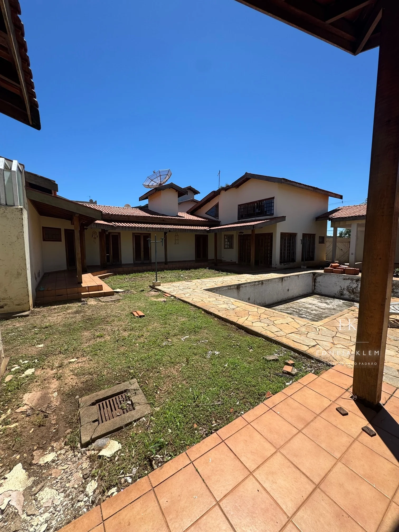 O gramado, a piscina e o sobrado ao fundo — hoje